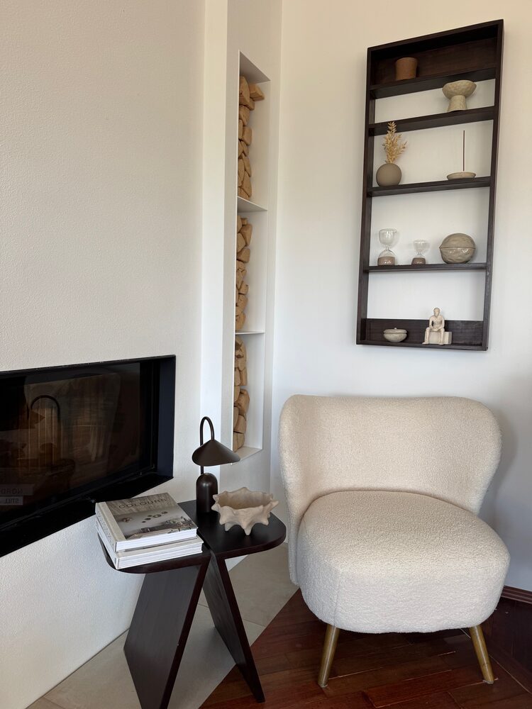 Warmes Interior mit Bouclé-Sessel und Kaminecke